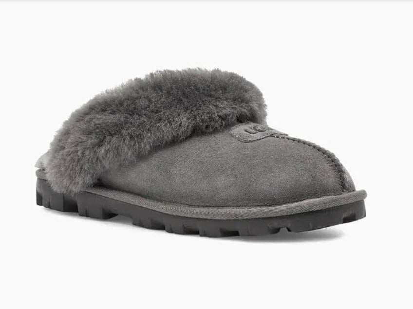 Coquette - The Classic Ugg Slipper in Grey. Nothing feels cozier than this Ugg classic slipper mule. Perfect for when you are working from home or walking the dog. Suede sheepskin upper & sock lining, lightweight full rubber sole.